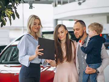 Die junge Familie unterzeichnet das von Autoankauf Bergheim fertiggestellte Angebot